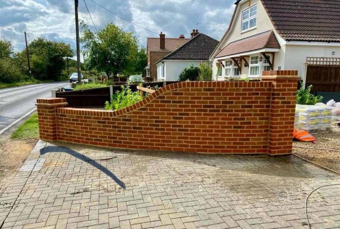 Newly built curved red-brick garden wall by Purely Pointing in Essex